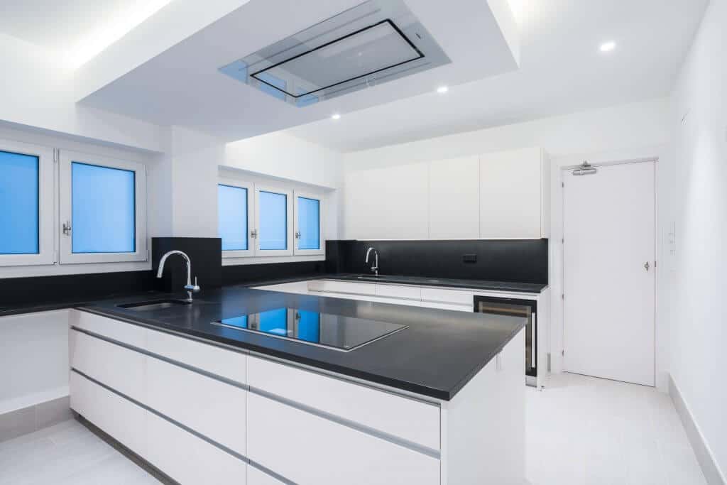 Cocina con Península Blanca y Encimera Negra - Grupo Coeco