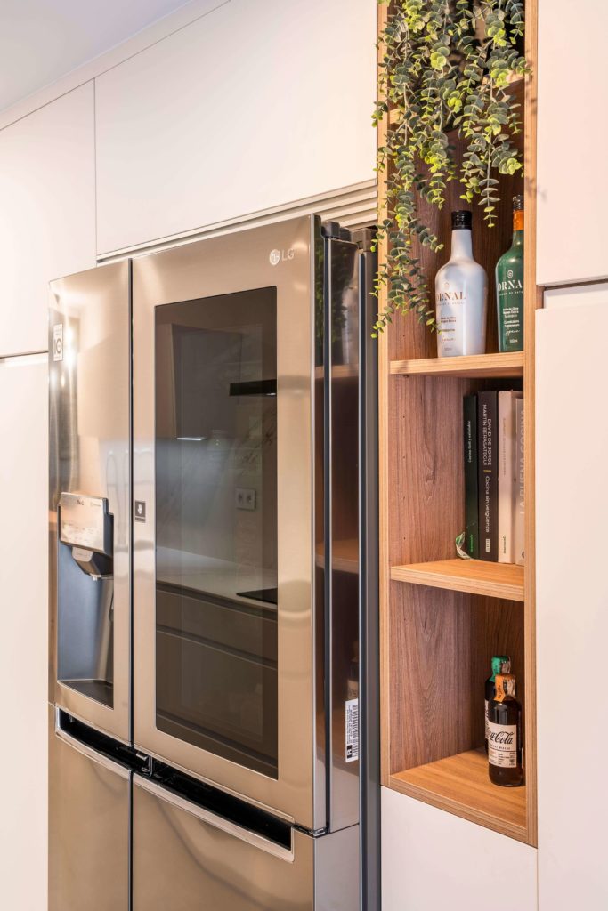 Cocina estratificada blanca con nevera de dos puertas y mueble de madera