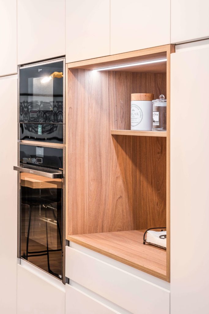 Cocina estratificada blanca con mueble de madera a medida