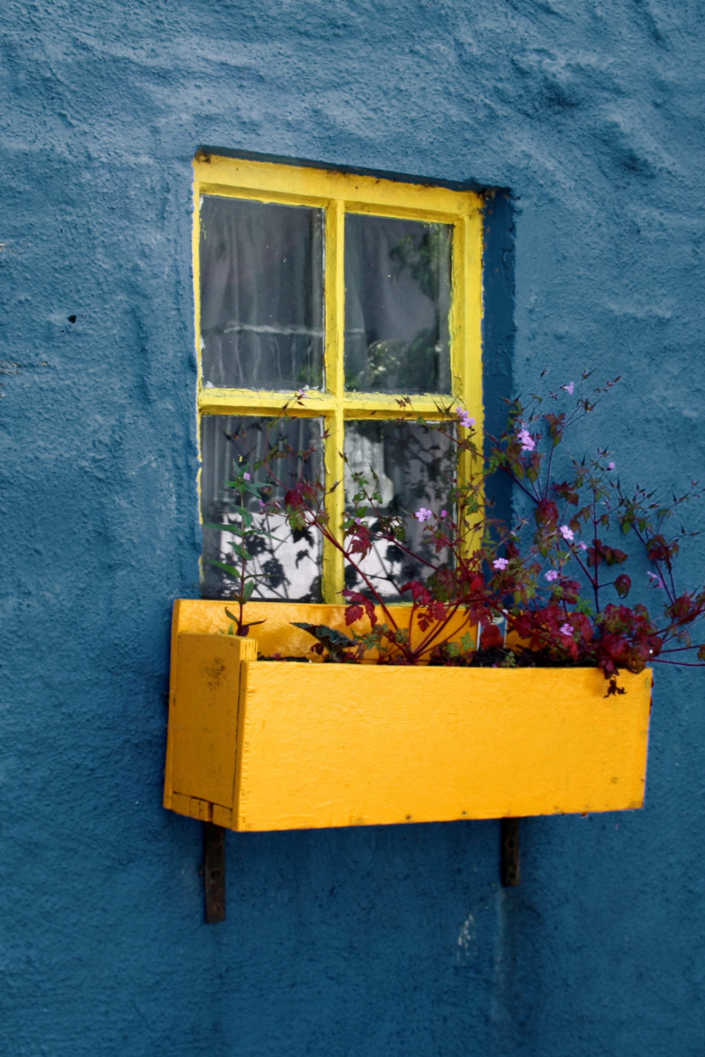 ventana amarilla sobre una pared azul