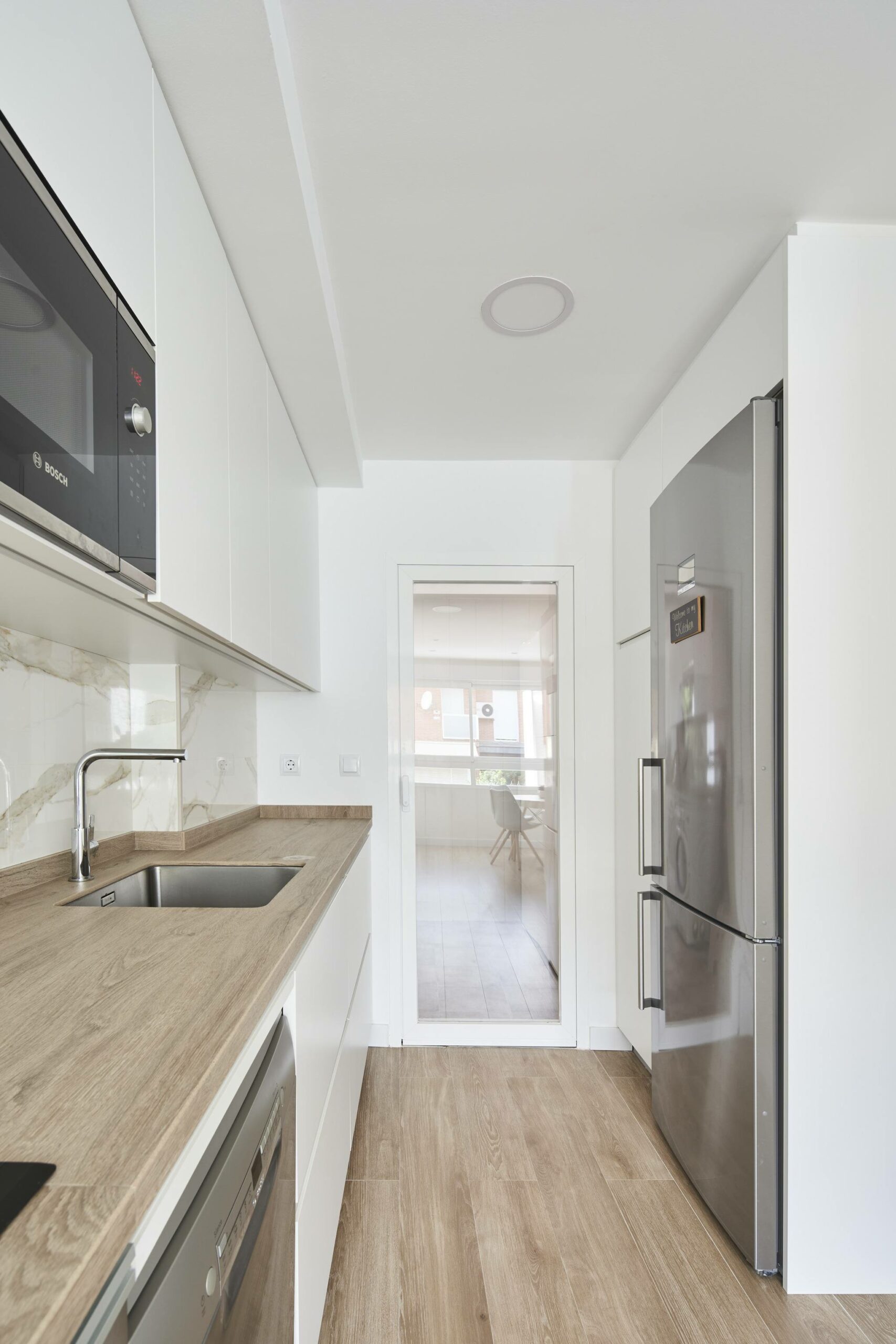 Cocina en dos frentes estratificada blanca con encimera color madera