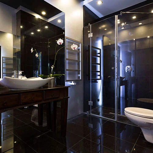 Cuarto de baño con diseño en color negro, retroiluminado