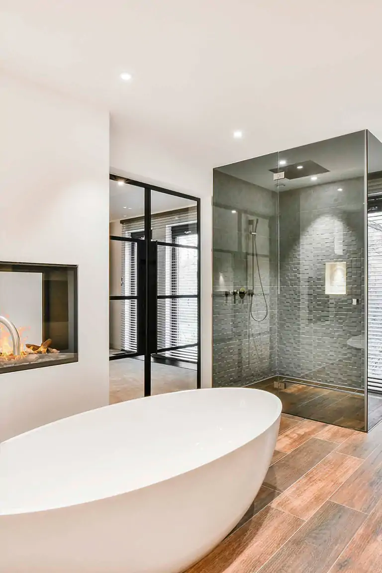 Este baño contemporáneo exhibe una estética minimalista de lujo, con una clara influencia del estilo escandinavo moderno fusionado con elementos industriales ligeros.