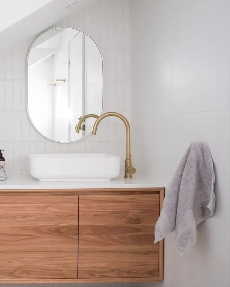 Mueble de baño moderno de madera – diseño contemporáneo y elegante. Mueble de baño moderno de madera con lavabo blanco y grifería dorada.