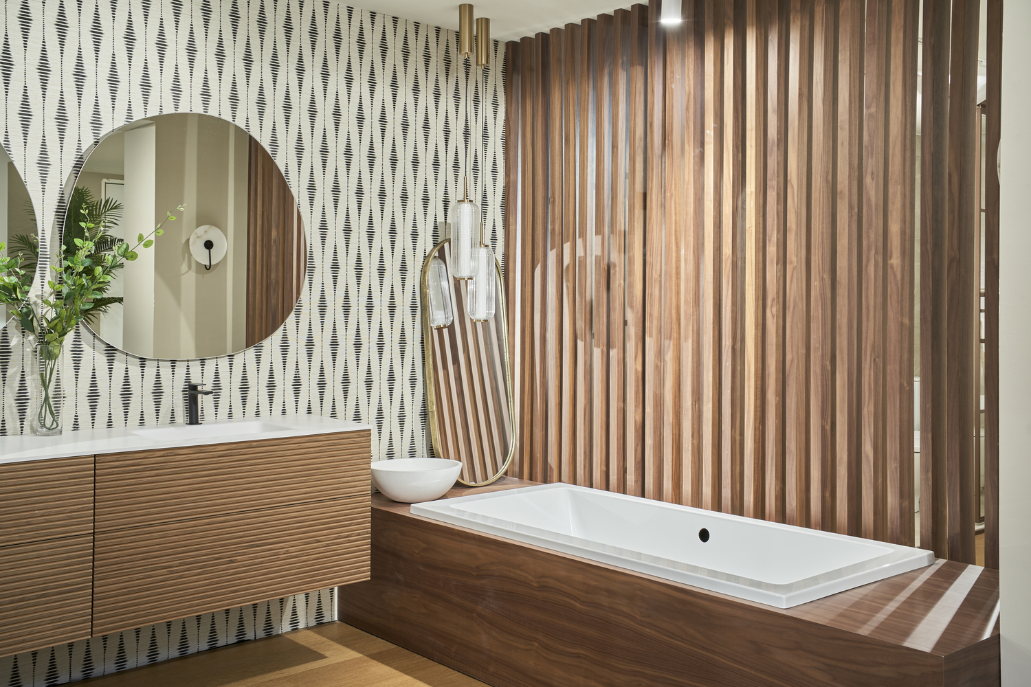 Baño contemporáneo con bañera integrada en estructura de madera, lavabo suspendido y pared decorativa con patrón geométrico.