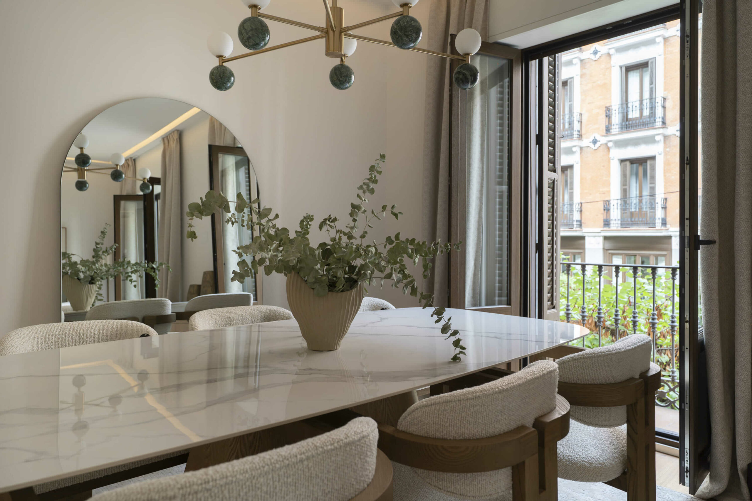 Comedor elegante con mesa de mármol y sillas bouclé