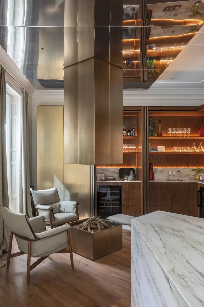 Cocina de lujo moderna en Madrid con isla de mármol, chimenea central y acabados en madera